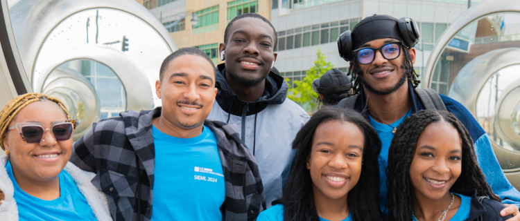 Six scholars at an outdoor event