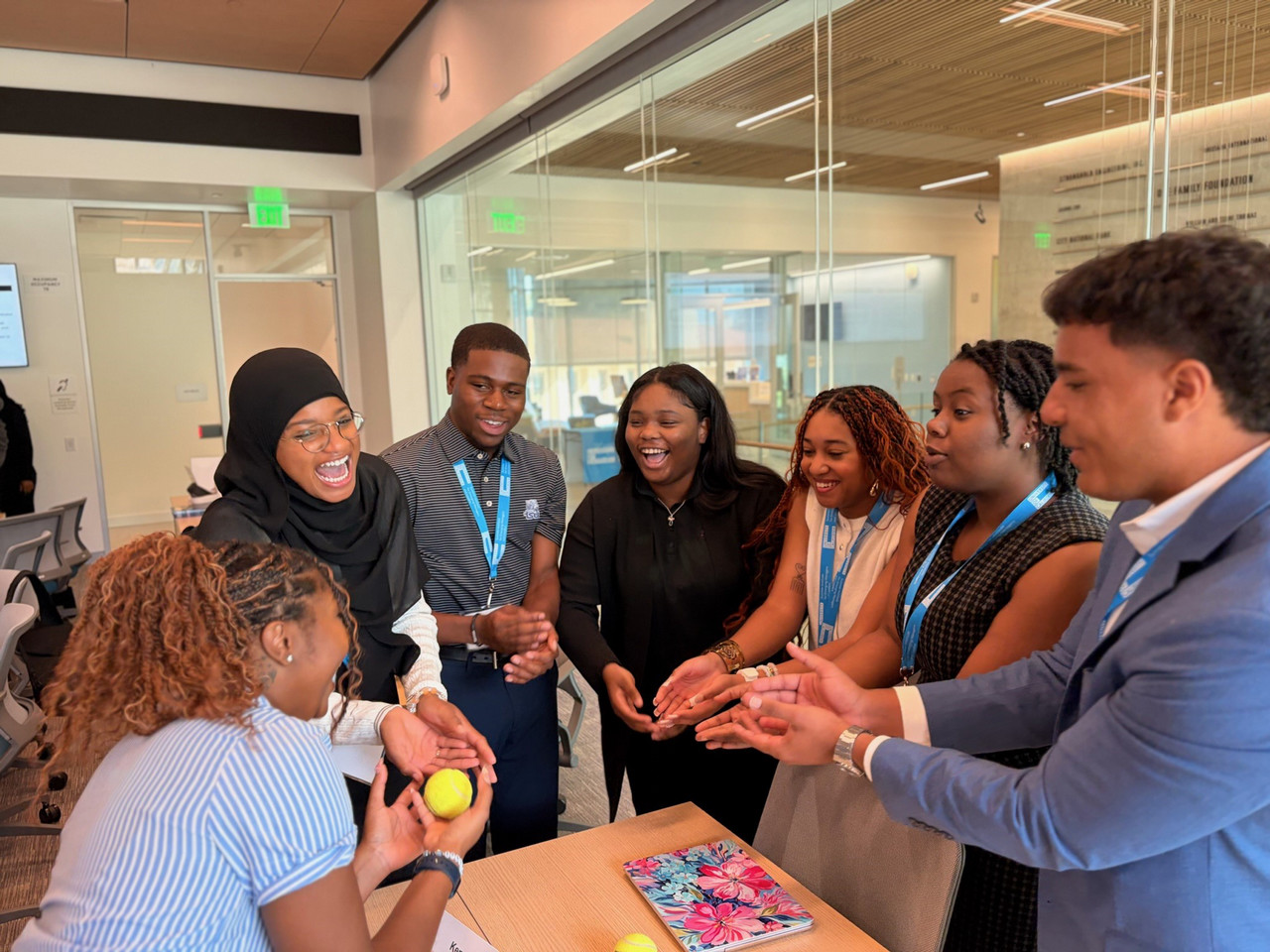Students gathering in a circle, laughing while they work on an assignment